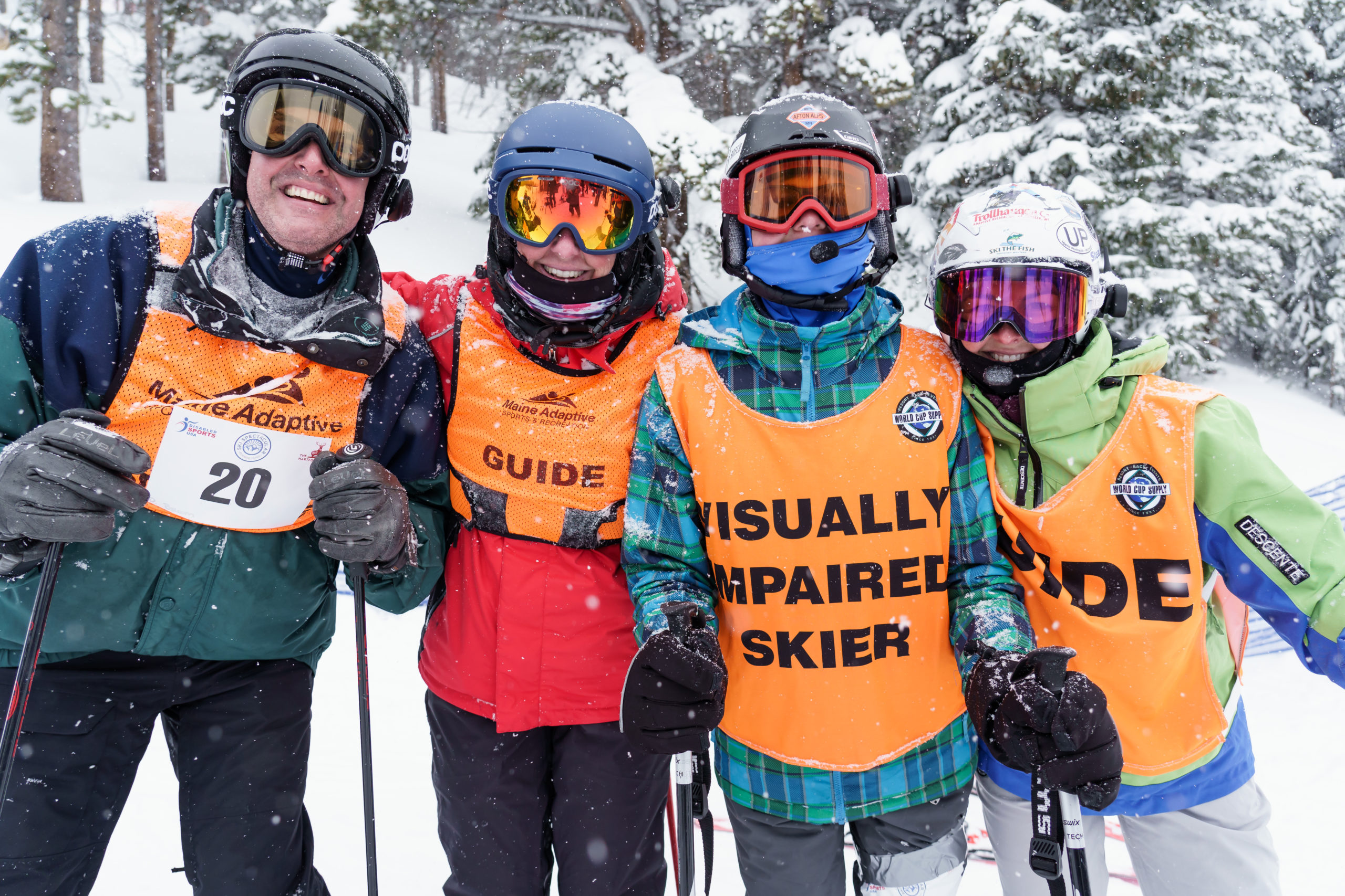 Four Ski Spec athletes smiling, posed in front of camera