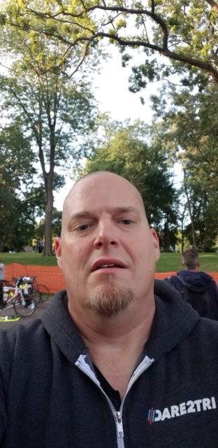 Male wearing a black sweatshirt looking at the camera