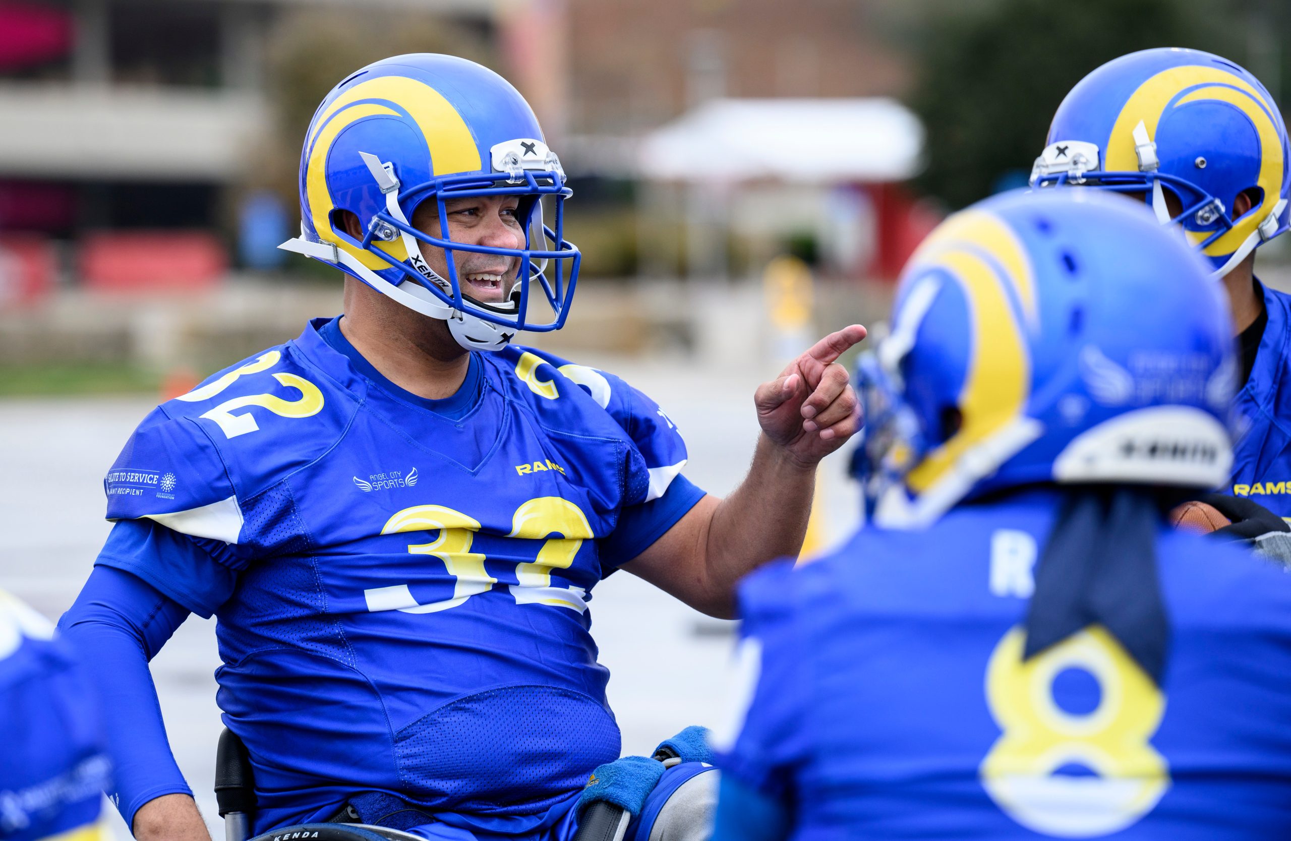 Member of the Los Angeles Rams smiles and points to his teammates