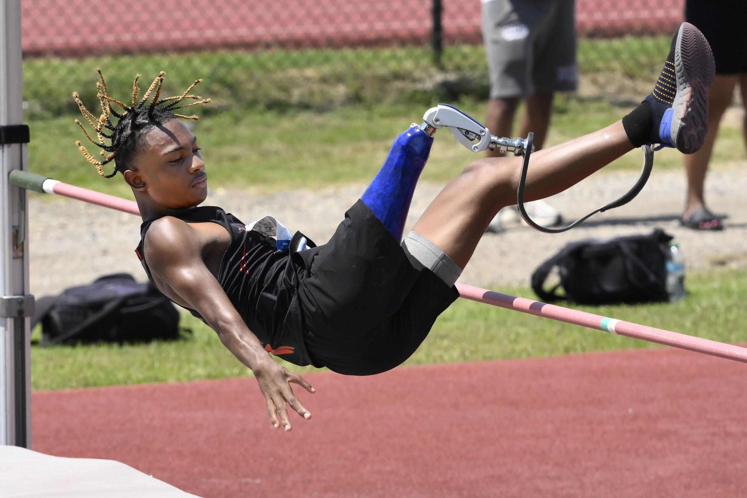 An athlete with leg amputation jumping over a high bar